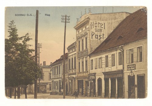 Numer inwentarzowy: MŻo/188; Materiał: papier; Technika: drukarska; Wymiary: długość - 13,6 cm, szerokość - 8,8 cm; Datowanie: 1905-1921 r.; Wydawca: Paul Hunold, Sohrau (Żory) 
Poczt&oacute;wka kolorowa, w formacie poziomym, bez obiegu, przedstawiająca południową pierzeję żorskiego rynku z hotelem ZUR POST (Pod Pocztą) na pierwszym planie. 
Napis na poczt&oacute;wce w języku niemieckim: Sohrau O/S. Ring.