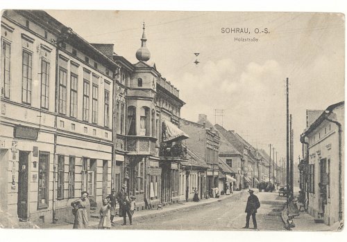 Numer inwentarzowy: MŻo/1481; Materiał: papier; Technika: drukarska; Wymiary: wysokość &ndash; 8,9 cm, szerokość &ndash; 13,8 cm; Datowanie: 1910-1914; Wydawca: Paul Hunold, Sohrau (Żory) 
Poczt&oacute;wka czarno-biała, w formacie poziomym, obiegowa, przedstawiająca dzisiejszą ulicę Moniuszki w Żorach. Poczt&oacute;wka nadana z Żor do miasta w prowincji G&oacute;rna Austria (Austro-Węgry) 7 grudnia 1914 r. prezentująca życie codzienne w Żorach na &oacute;wczesnej ulicy Holzstra&szlig;e (Drzewnej).