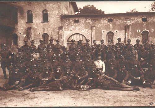 Wymiary: wysokość - 8,8 cm; szerokość - 13,9 cm; Materiał: papier fotograficzny; Technika: fotograficzna, sepia; Pochodzenie: Żory, G&oacute;rny Śląsk; Datowanie: lata 1922-1939; Autor: brak danych 
Fotografia sepia przedstawiająca portret zbiorowy żołnierzy II Dywizjonu 23 Pułku Artylerii Polowej w Żorach. Leżący w pierwszym rzędzie żołnierze trzymają w dłoniach tabliczkę z napisem:&nbsp; II/23 P.A.P. 4 bat. 
Na drugim planie widoczne zabudowania garnizonowe w Żorach.
